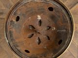 an overhead view of a rusted metal bowl on a parquet floor