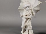 pair of porcelain figurines of a boy and a girl with umbrellas