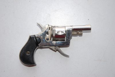 a silver revolver with a black handle on a white surface