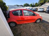 a small red car parked in a parking lot