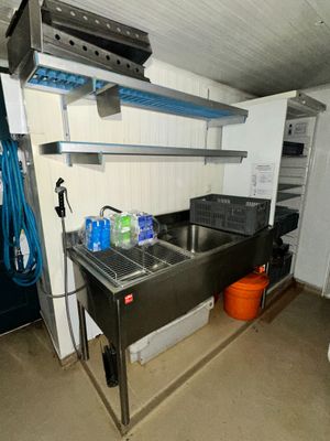a kitchen with a sink, stove, and other items in it