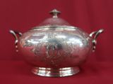 an antique silverplated teapot on a red background