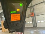 a parking meter with a sticker on it in a warehouse