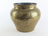 un vase en or posé sur une surface blanche