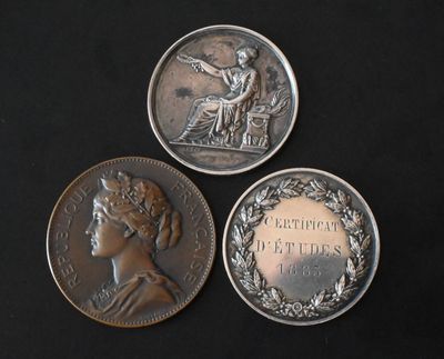 three silver coins with a woman on them on a black surface