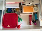 a drawer full of school supplies on the desk
