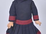 an image of a doll of a girl in a blue dress and red tights