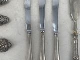 a lot of silver spoons and knives on the table