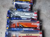 Plusieurs camions miniatures sont alignés dans des sacs en plastique posés par terre.