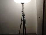 une lampe posée sur un trépied dans une pièce