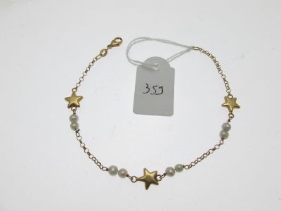 un gros plan d'un bracelet avec une étoile suspendue à une chaîne