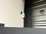 a door with a green handle and a white face on it