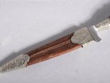 a knife with a wooden handle on a white surface