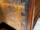 a close up of a wooden table with a drawer underneath it