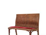 a wooden bench with a red cushion on top of it