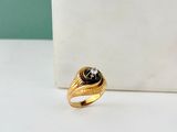 un gros plan d'une bague en or ornée d'une pierre noire au centre