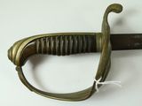 a close up of a sword on a white surface