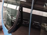 a blue bus parked in a garage next to a white van