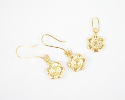 a pair of gold earrings with a flower design on them