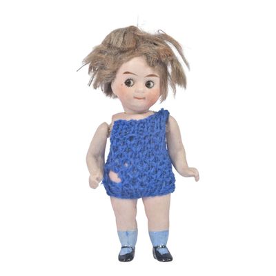 a small doll that is wearing a blue dress and socks