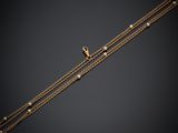 a gold chain bracelet with pearls and a gold clasp
