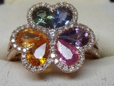 une image représentant une bague ornée de pierres multicolores et de diamants