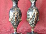 une paire de vases noirs et dorés sur fond rouge