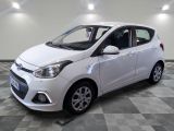 la voiture blanche est garée sur le sol à carreaux d'un garage