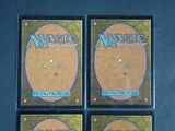 four magic the gathering deck protectors are shown on a table