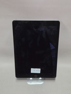 une image représentant un ordinateur Apple noir posé sur une table blanche