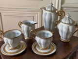 five cups and saucers on a table with gold trimming