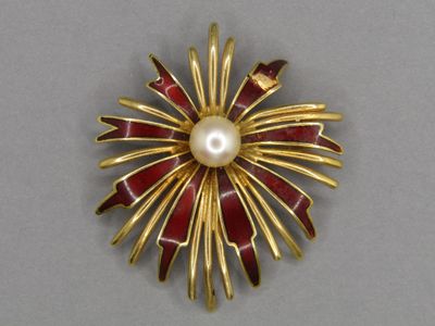 gold and red broochle with a pearl in the center