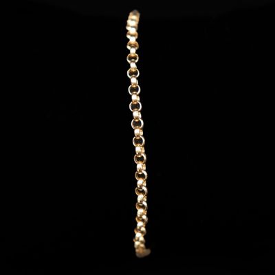 gros plan d'un bracelet en or sur fond noir