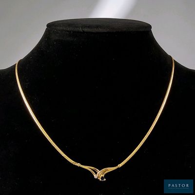 un gros plan d'un collier en or autour du cou d'un mannequin
