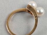 an image of a gold ring with two pearls on it
