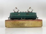 a green train on a wooden platform on a white surface