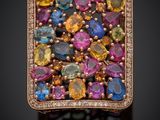un gros plan d'une bague ornée de pierres multicolores et de diamants