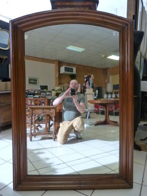 Important miroir en noyer mouluré et fronton cintré .