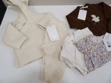 a box of baby clothes and a sweater on a table