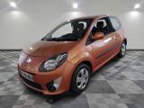 une photo d'une petite voiture orange garée dans un garage