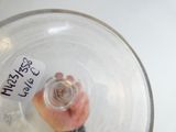 une personne tenant un verre d'eau sur lequel est apposée une étiquette