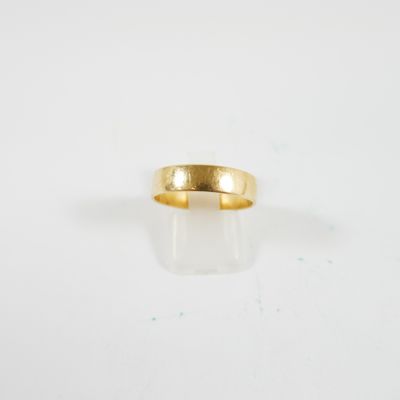 gros plan d'une bague en or sur une surface blanche
