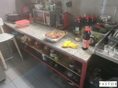 une cuisine équipée d'une cuisinière, d'un évier, d'un micro-ondes et d'un plan de travail