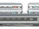 three trains that are sitting side by side on a white surface