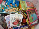 de nombreux livres pour enfants dans un panier posé par terre