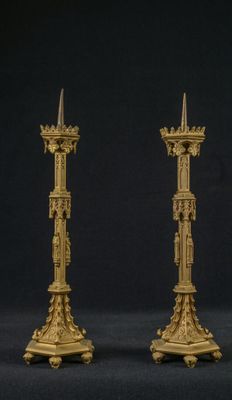 paire de bougeoirs anciens en laiton sur fond noir
