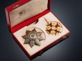 a red box with a silver medal and other items in it