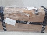 a large stack of boxes wrapped in plastic on the floor