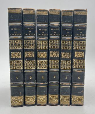 six old books are lined up in a row on a white surface