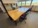 une salle de réunion vide avec une longue table et des chaises violettes